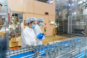 Workers checking production lines in a food processing facility during daytime operations