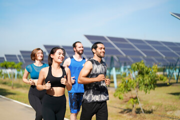 Fototapeta premium Friends jog together in a sunny park near solar panels in the morning hours