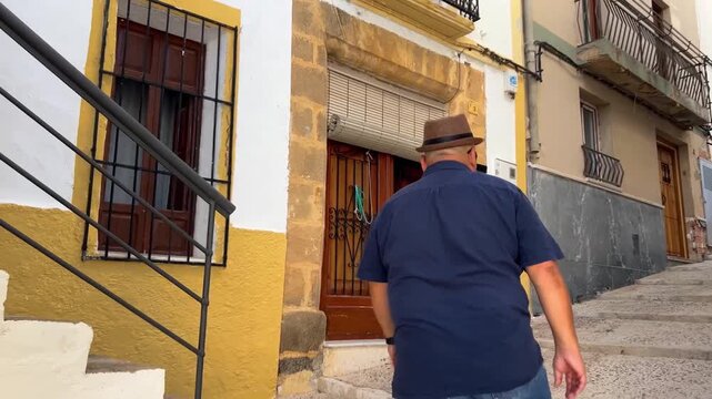 Hombre subiendo escalones en casco antiguo de Teulada