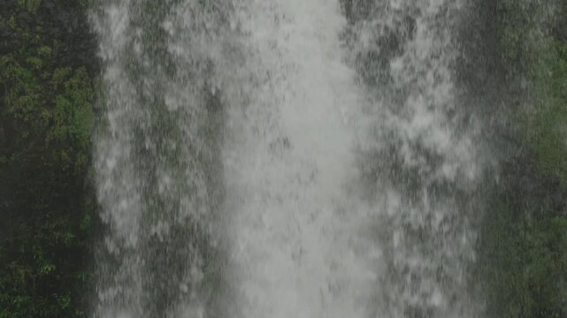 Slow motion descending motion view of large cascade as it is falling down from large heights making vapor and steam in the surrounding air.