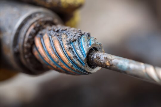 Plumber inserting spiral cable into clogged pipe