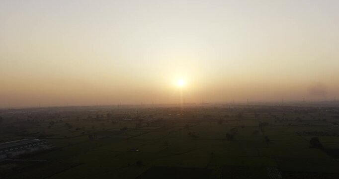 serene sunrise over a vast, rural landscape, likely a countryside field or farmland