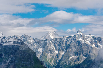 Obraz premium Majestic Peak of Mount Bietschhorn Rising Above Clouds in the Swiss Alps. View from the Via Alpina trail near Bunderspitz. 