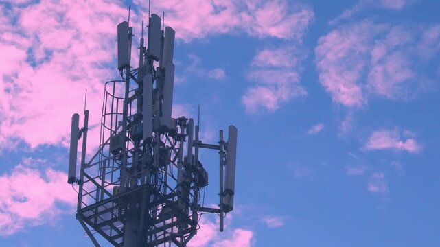 Cellular tower Close-up, Antenna, Equipment of Mobile Operator, Cell Tower Closeup, Mobile Communication Transmitter, Antenna and  Pink Clouds in the Blue Dawn Sky Aerial View, Time Lapse.