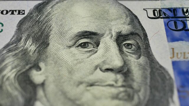 Close up of 100 dollar bill showcasing Benjamin Franklin face. Currency issued by government to facilitate exchanges. Paper money as state-backed medium of exchange for goods and services