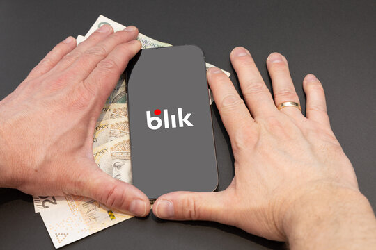 Czestochowa, Poland February 2A nervous man clenches his fists, hits his hand and the desk, a mobile phone is prepared for a BLIK online transfer, a hacker is preparing to commit online fraud on BLIK,
