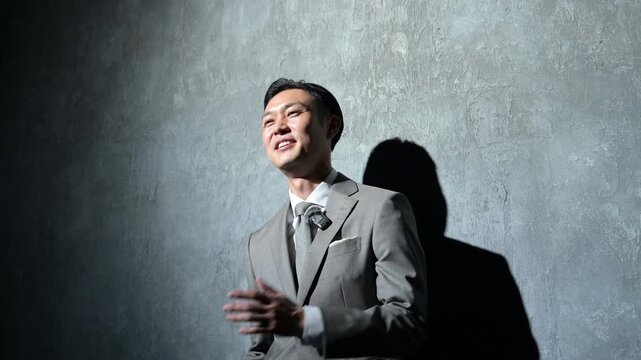 ピンマイクをつけてプレゼンをするスーツの日本人男性