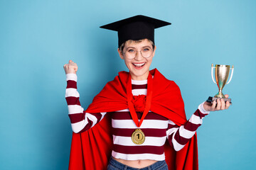 Young student graduate celebrating victory wearing graduation cap red cape striped sweater medal...