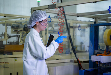 Food scientist inspecting canned fish production line
