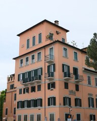 Fototapeta premium Peach-colored urban apartment building with balconies and multiple windows