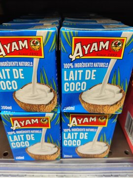 Saujon, France - January 24, 2026: Intermarche. AYAM coconut milk cartons stacked on a shelf, featuring blue packaging with natural ingredients and coconut imagery