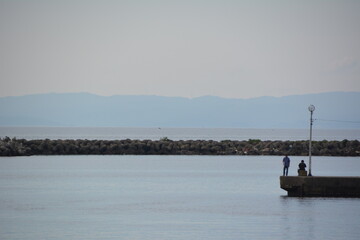 港の堤防で釣りをする人