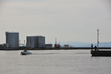港を走るボートと工業地帯