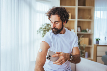 Man Checking Continuous Glucose Monitor With Smartphone At Home — Diabetes Health And Wellness