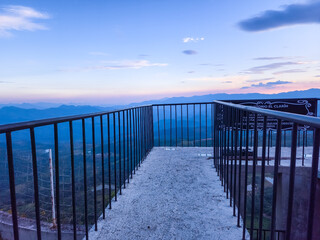 Fototapeta premium A metal railing overlooks a beautiful mountain range
