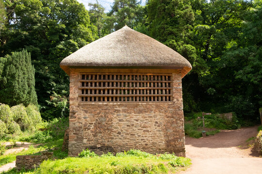 Thatched C17 stone cottage "Gamekeepers Cottage" in the picturesque village of Cockington,Devon,England,UK. Wooden slats were for hanging pheasants
