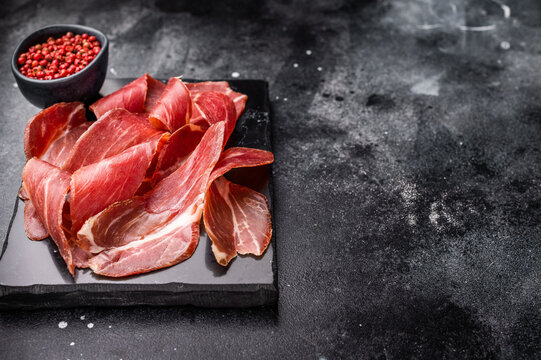 Sliced prsut prshut, Balkan cured pork meat ham. black background. top view
