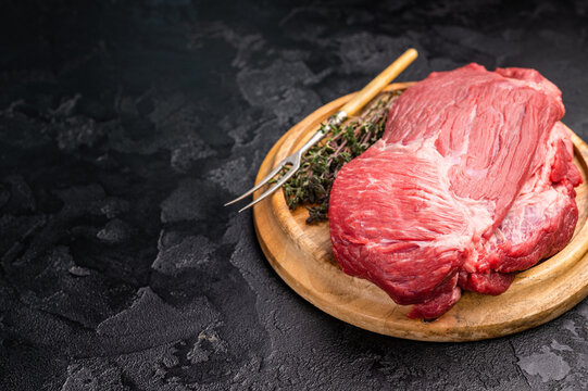 Raw Silverside Round beef meat piece , fresh bottom round on wooden board. black background. Top view