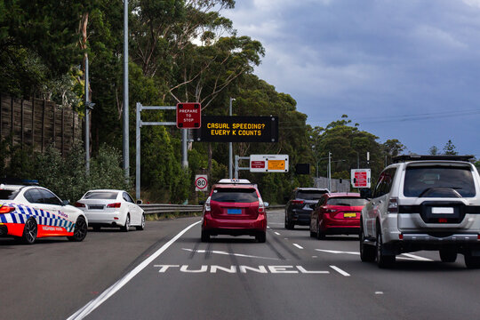 car pulled over by police with traffic passing and casual speeding? Every k counts sign