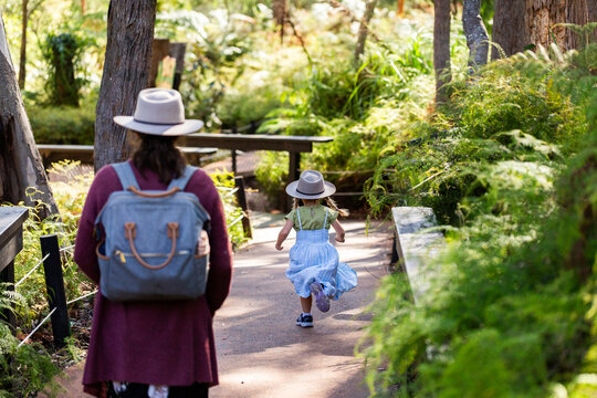 child with adult following down pathway between native bushland at zoo