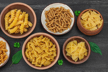 Pasta. Various kinds of uncooked pasta and noodles over wooden background. Traditional Italian