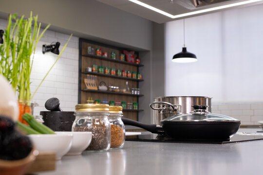 Modern kitchen interior with cooking pans and ingredients on counter