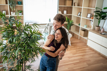 Happy couple enjoying home life and caring for plants