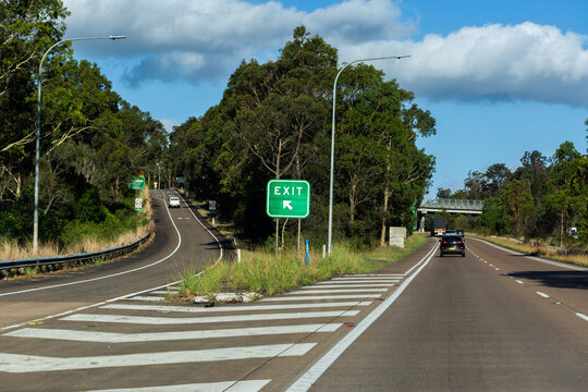 Highway exit sign to the left on road trip through Australia