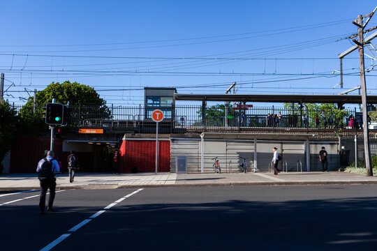busy city train station platform in Narwee Sydney seen across road on sunny morning