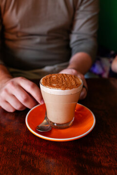chai latte drink on table at caf&eacute; with mans hands in background