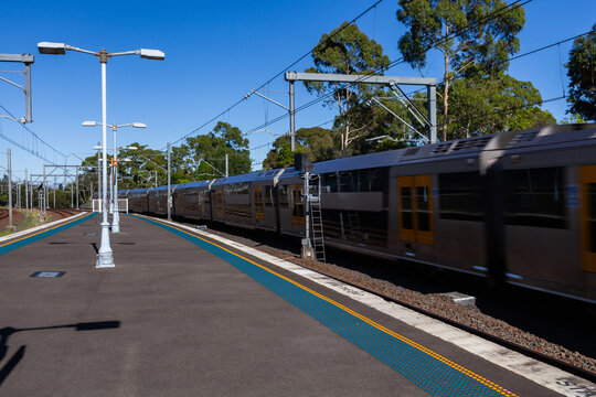 Passenger train passing platform of Narwee station in Sydney suburb