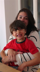 Mother hugging young boy, warm affectionate embrace, genuine family connection, heartfelt moment of...