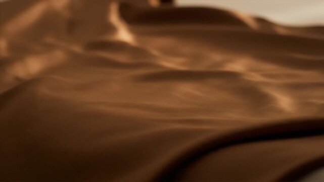Close up of elegant flowing brown fabric with soft textures and highlights