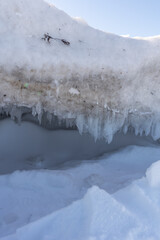 Dramatic coastal ice buildup on Baltic seaside, crystal icicles and snow layers capturing extreme cold and seasonal change.