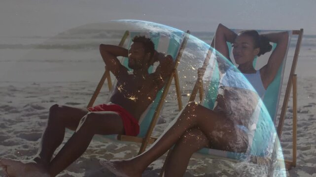 Couple settling into beach chairs gazing ocean midframe globe overlay rising showing travel theme