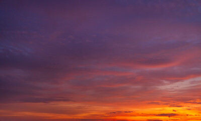 Obraz premium Panoramic Vibrant Sunset Sky with Purple and Golden Gradients,A breathtaking panoramic view of a twilight sky during sunset, featuring a seamless color transition from deep purple and violet to warm.