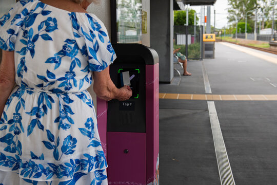senior woman tapping on at the train station