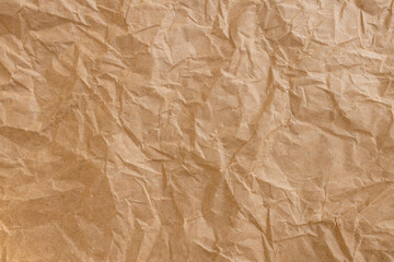 Fototapeta premium Crumpled Brown Kraft Paper Texture Background,Top view of brown crumpled recycled kraft paper texture. Abstract wrinkled paper background with rough creases and shadows, perfect for organic,