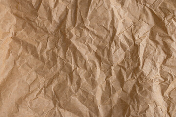 Fototapeta premium Crumpled Brown Kraft Paper Texture Background,Top view of brown crumpled recycled kraft paper texture. Abstract wrinkled paper background with rough creases and shadows, perfect for organic,