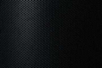 Naklejka premium Black perforated metal grill texture background with gradient light,Macro,Close-up of a black metallic perforated mesh surface. The pattern features circular holes in a geometric honeycomb-like.