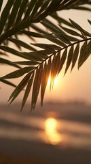 Fototapeta premium Palm Leaf Silhouette Against Golden Sunset Over Water With Sunburst Effect and Blurred Background Creating a Warm Tropical Evening Vibe