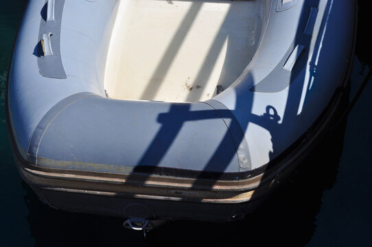 Nautical travel concept: durable rubber dinghy on the sea surface with hard shadows
