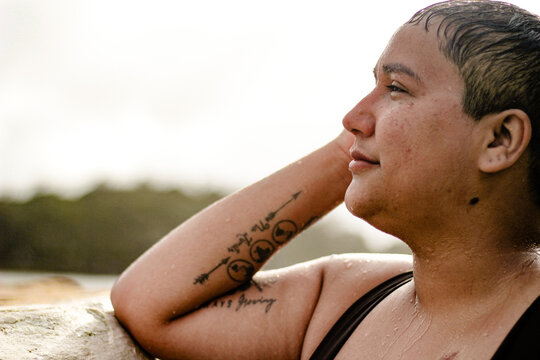 French Islander woman lifting one hand in the tidal pool side profile