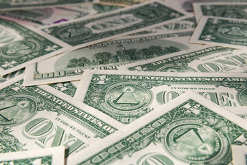 Macro Close-up of Scattered US Dollar Bills with Focus on One Dollar Pyramid
