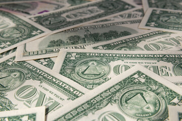 Macro Close-up of Scattered US Dollar Bills with Focus on One Dollar Pyramid