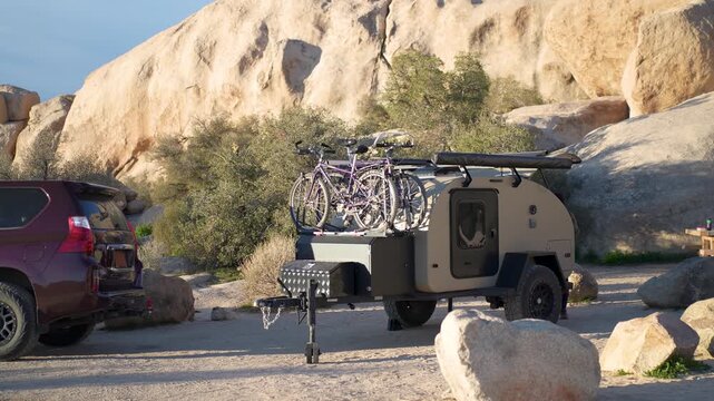 Enjoy camping with an SUV and teardrop camper trailer in Joshua Tree National Park with bikes ready for adventure.