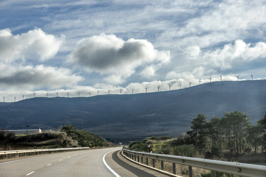 Silhouettes of wind turbines on a hill in Soria province, Central Spain, against a dramatic cloudy sky
