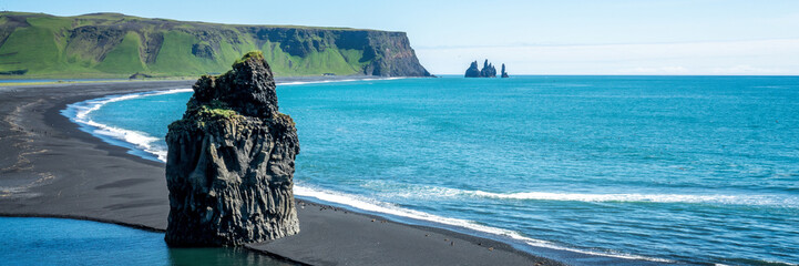 Panoramic view of Reynisfjara, a famous black sand beach in the South Coast, Iceland travel header © Delphotostock