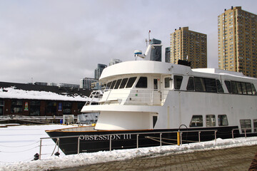 Obraz premium Toronto, Canada - February 15, 2026: Winter harbor scene in Toronto with docked white yacht Obsession III amid snowy waterfront
