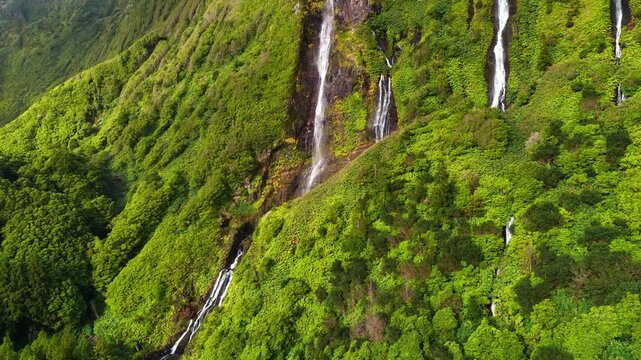 Scenic revealing aerial view of Cascada Da Ribeira Do Ferreiro waterfall on Flores island, Azores archipelago, jungle waterfall in the Azores, travel in Portuguese Atlantic islands